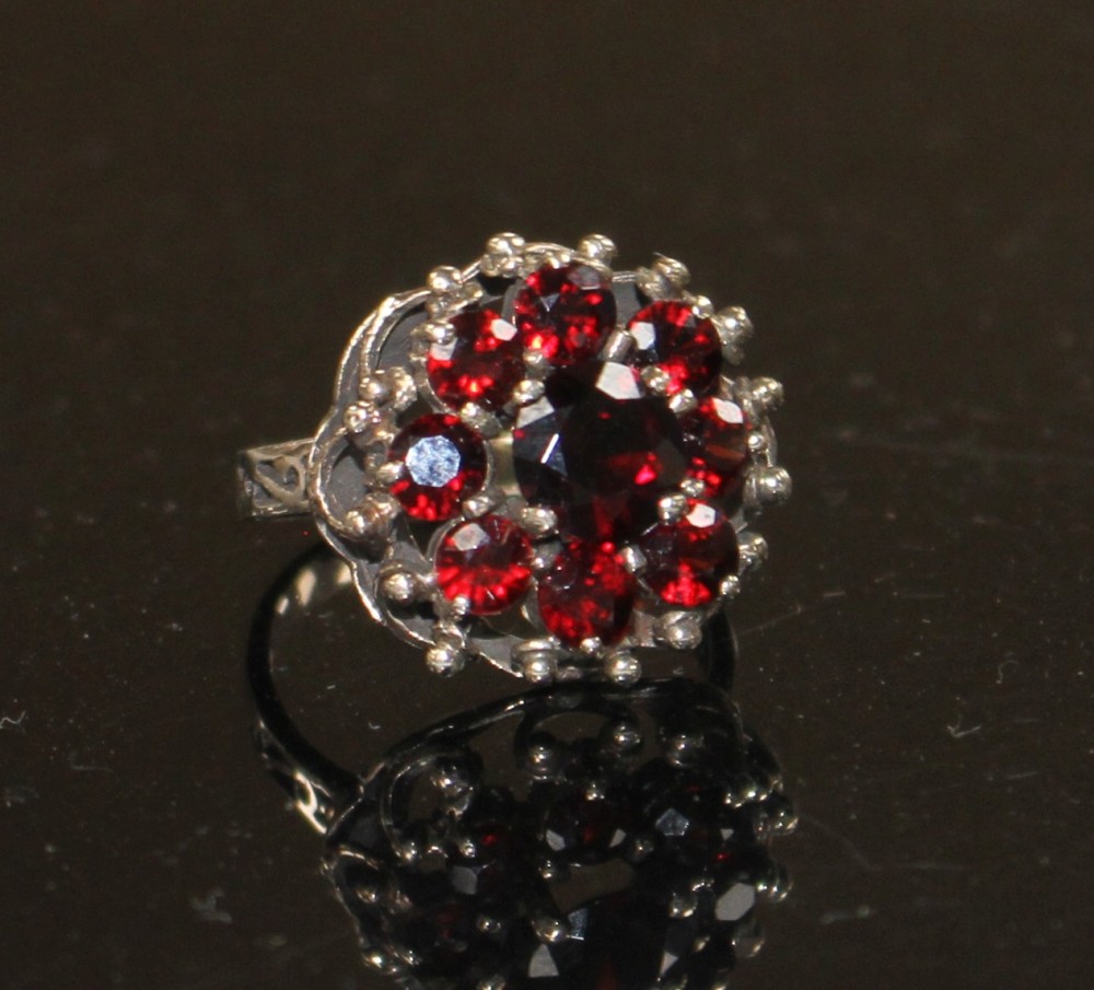 A 14k yellow metal and nine stone garnet cluster dress ring, size O, gross weight 5.6 grams.